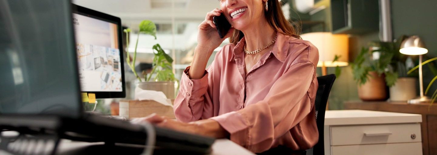 Conseillère souriante au téléphone à son bureau pour prendre contact