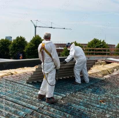 Techniciens en combinaison retirant une toiture en amiante-ciment