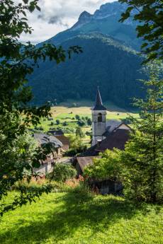 Village de montagne avec clocher entouré de verdure